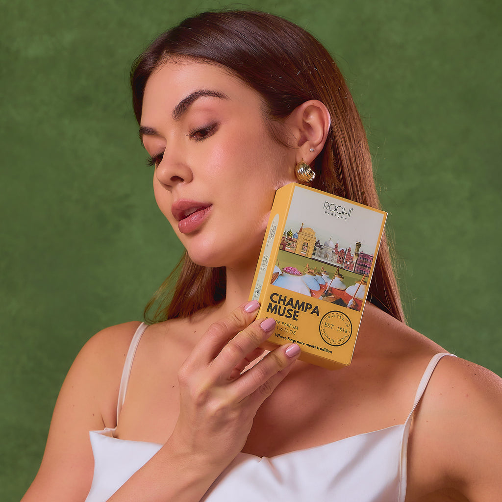 Yellow rectangular box of rooft parfums champa muse eau de parfum with illustrated cityscape and gold lettering
