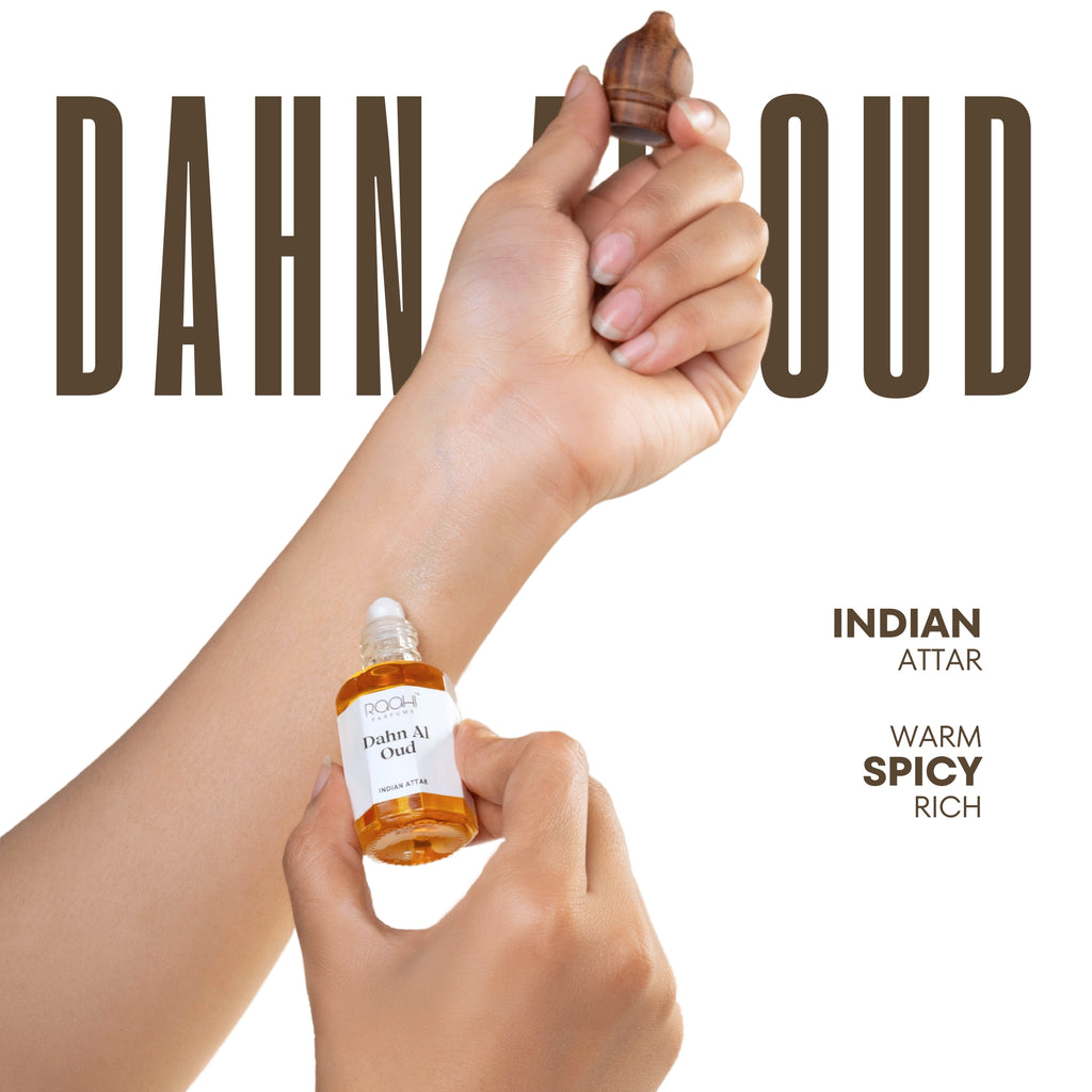 A small amber glass bottle of dahn al oud indian attar with a white label and dropper held with an acorn wooden applicator