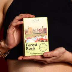 A pale green rectangular box of Roohi Parfums Forest Rush eau de parfum with architectural and market illustrations