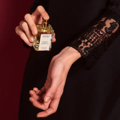A sleek transparent glass bottle of Roahi Parfums Mogra Madness eau de parfum with gold spray nozzle and white label