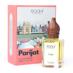 A clear glass bottle of raahi parfums parijat eau de parfum 50ml with wooden stopper and golden yellow liquid