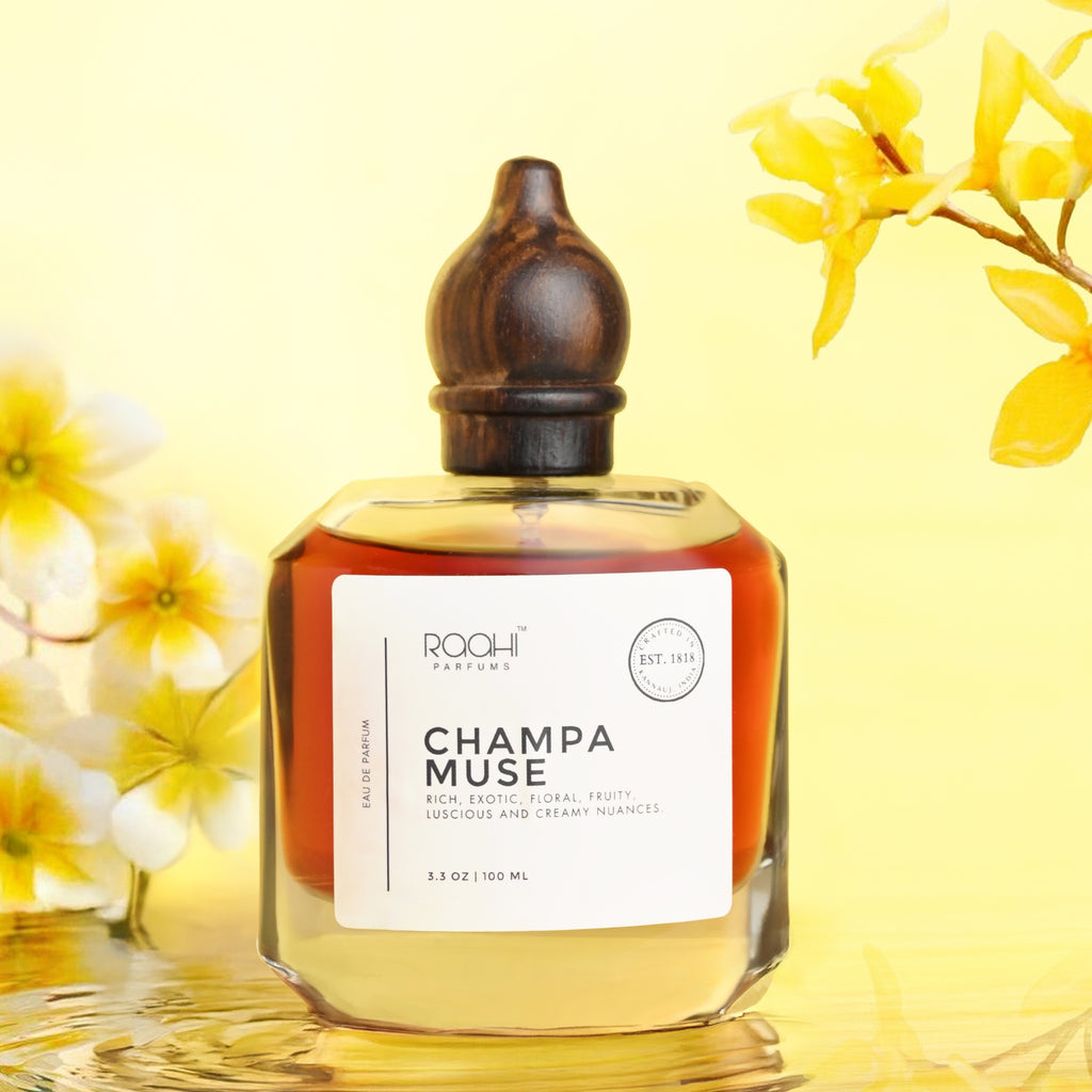 A sleek transparent glass perfume bottle with dark wooden stopper and white label champa muse by roohi parfums