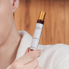 A sleek 12ml glass rollerball bottle with gold cap holding dark amber kasturi attar handcrafted in Kannauj