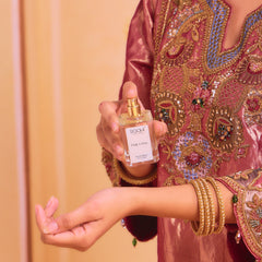 A clear glass bottle of poochi parfum pink lotus eau de parfum 50ml with gold-tone spray nozzle and minimalist white label