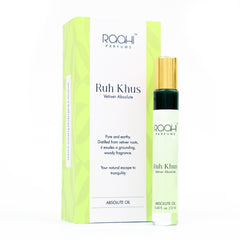 A sleek transparent glass rollerball bottle with gold cap and green band containing mint-green vetiver absolute oil
