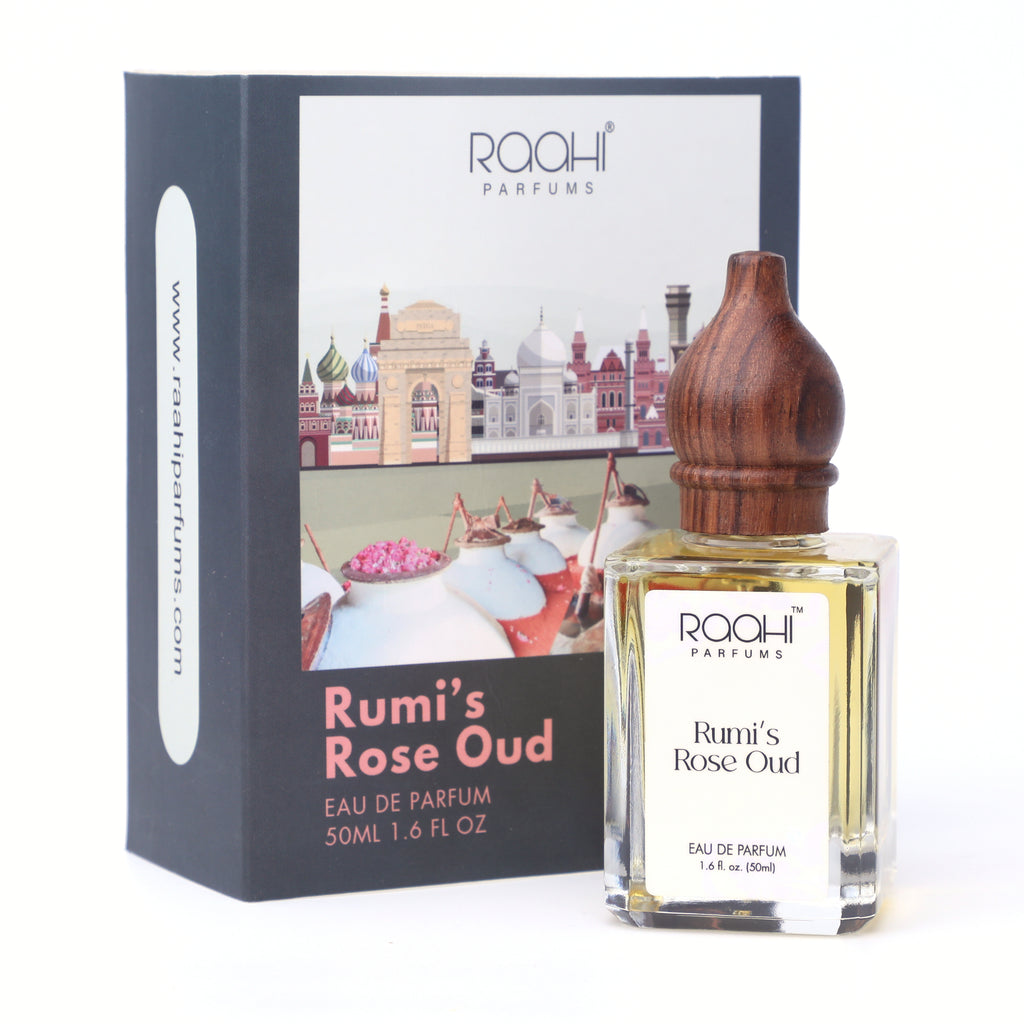 A clear glass bottle of rumis rose oud eau de parfum with a polished wooden stopper and branded packaging