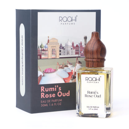 A clear glass bottle of rumis rose oud eau de parfum with a polished wooden stopper and branded packaging
