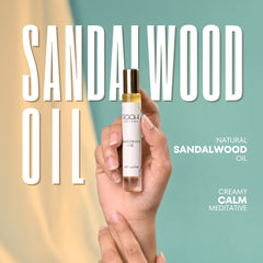 A sleek transparent glass bottle with gold cap holds golden sandalwood oil from Roohi Parfums 100% pure