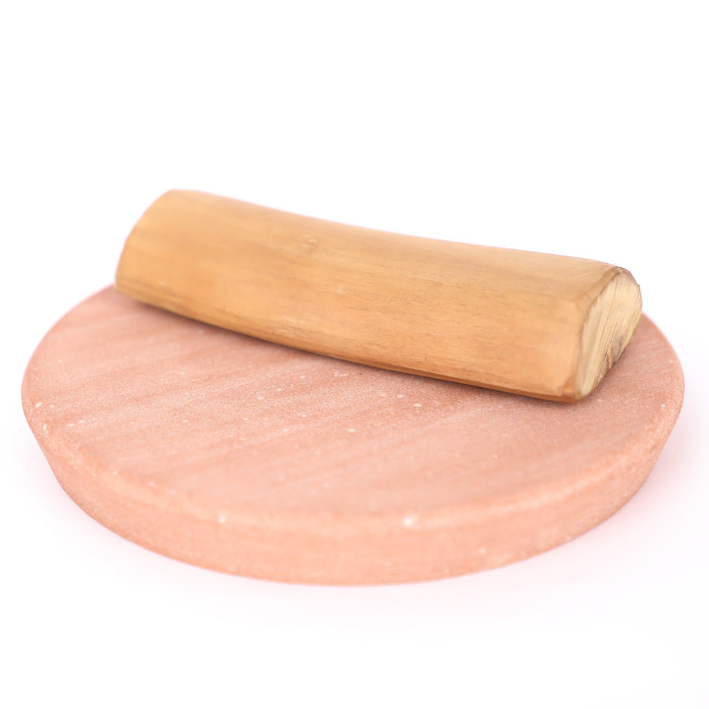 A smooth light pink himalayan salt stone mortar with matching wooden pestle for sandalwood log 50gm rubbing stone use