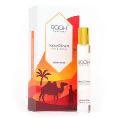 A sleek transparent glass rollerball bottle with a gold cap and white label for raahi parfums sunset desert oud and vanilla