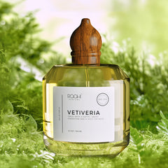 A clear glass bottle of Rqohi Parfums Vetiveria eau de parfum with a polished wooden cap and golden-yellow liquid