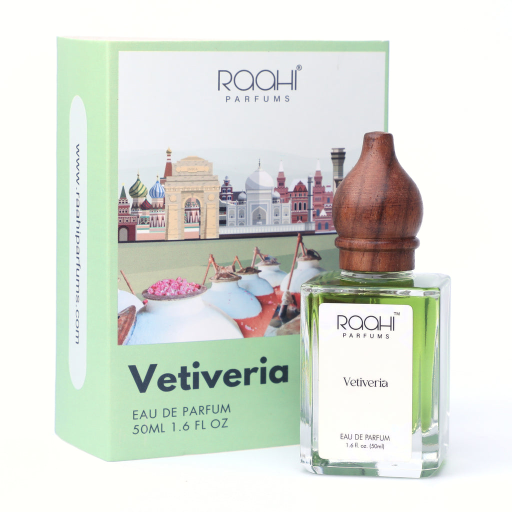 A clear glass bottle of raahi parfums vetiveria eau de parfum with green liquid and a polished wooden stopper