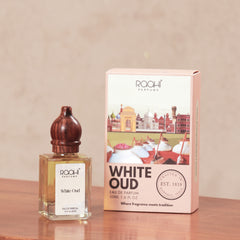 A clear glass bottle with dark wooden stopper holding amber-colored White Oud eau de parfum 50ml