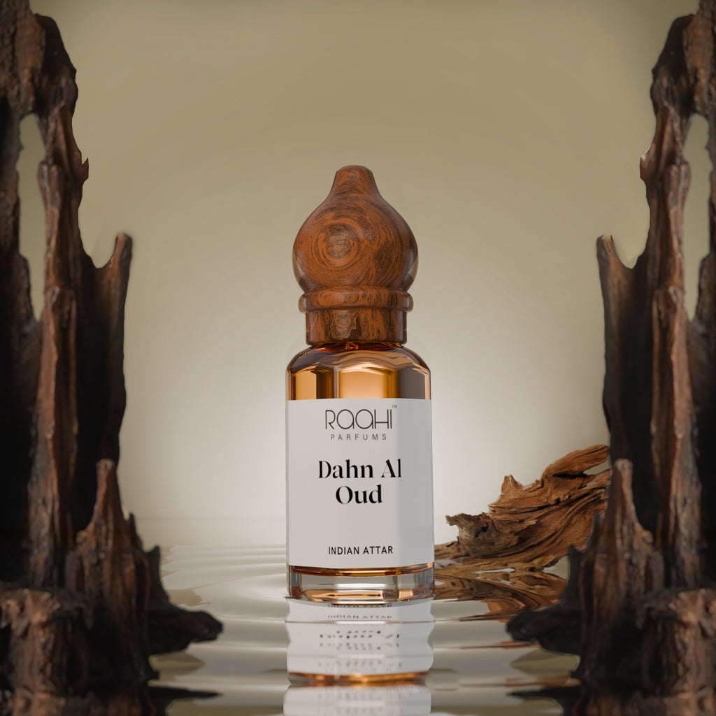 A sleek amber glass bottle of raahi parfums dahn al oud Indian attar with a hand carved wooden stopper and label