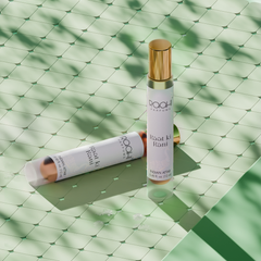 A sleek white rollerball perfume bottle with gold cap labeled roohi parfums raat ki rani indian attar 12ml